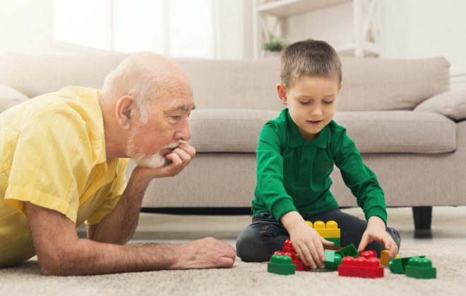 Boy playing with grandfather in building kit
