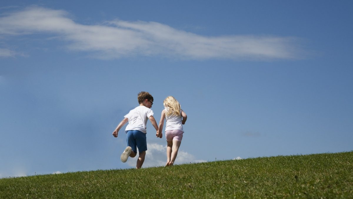 Two children running up a hill