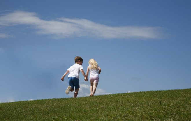 Two children running up a hill